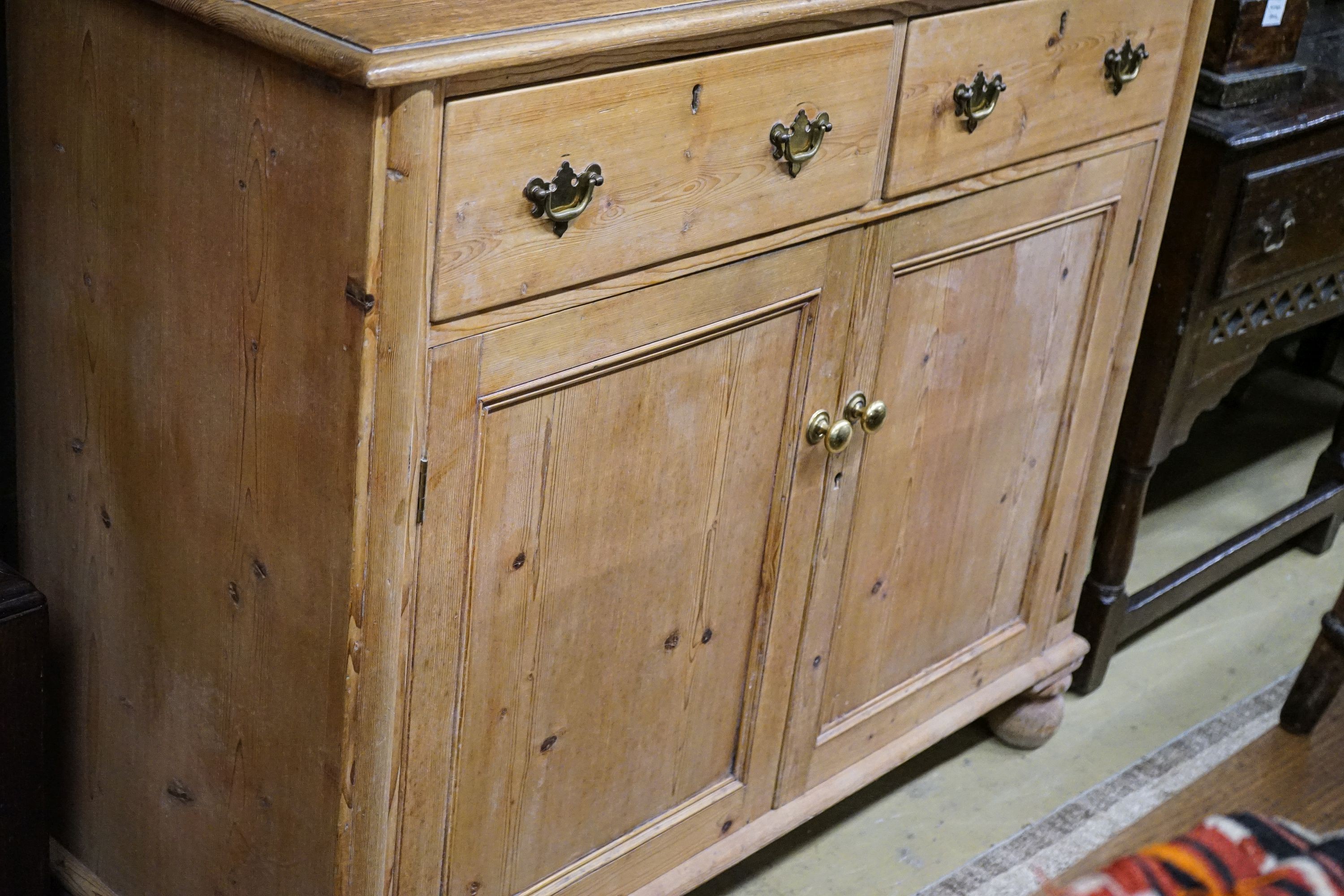 An early Victorian pine chiffonier, fitted two drawers and panelled doors on turned feet, width 121cm, depth 50cm, height 142cm